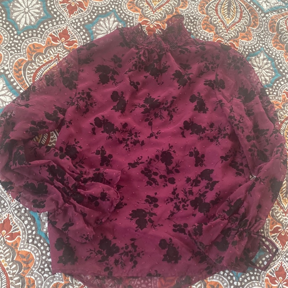 Deep wine/purple top with black flower detail and ruffle sleeves